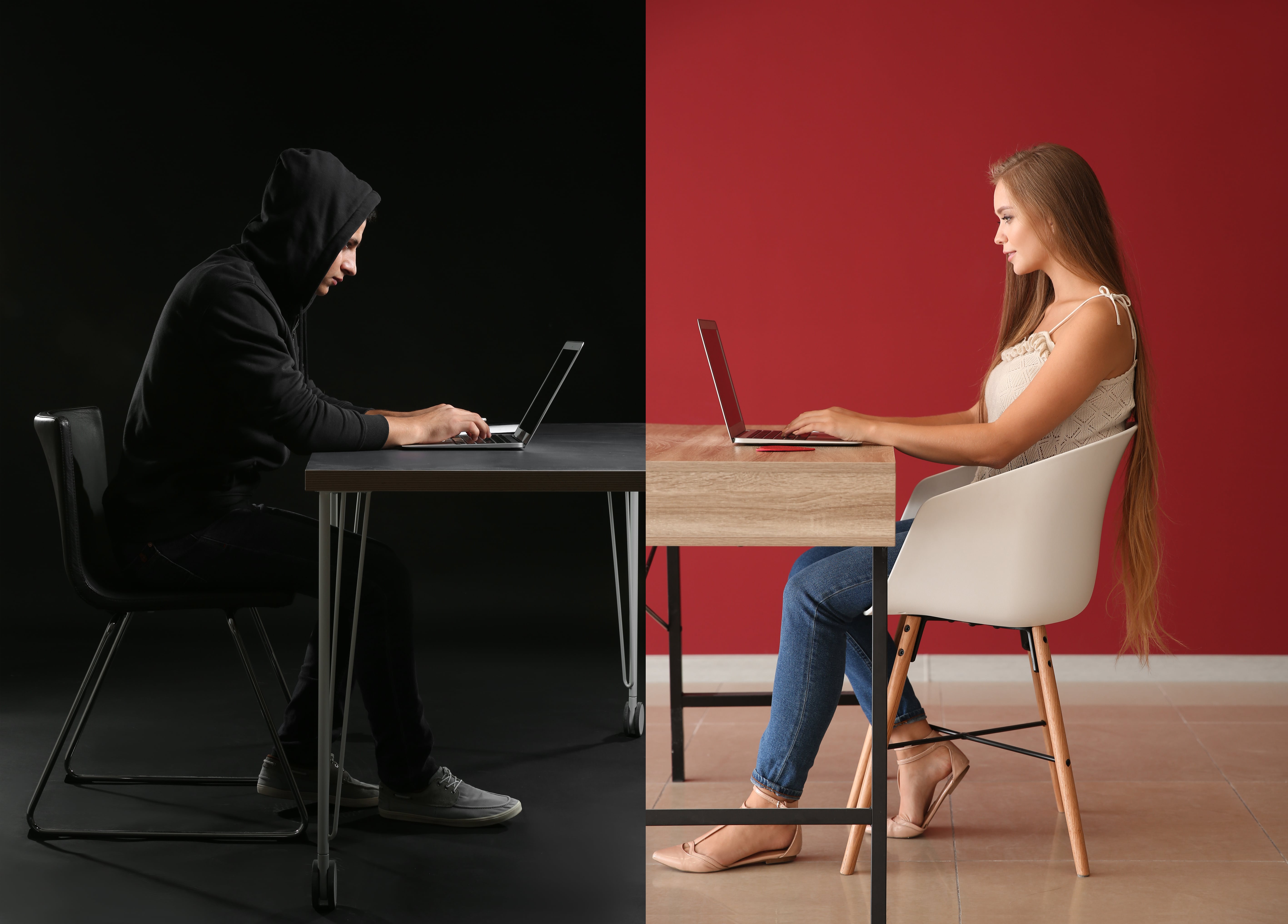 man in all black on computer girl on computer on other side